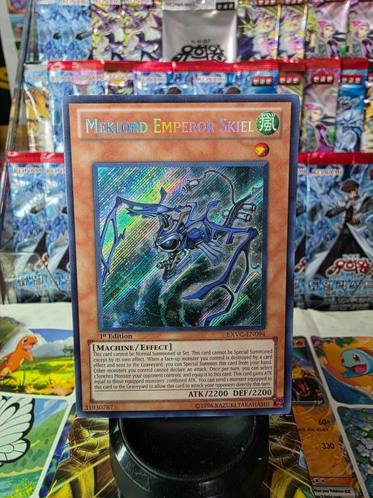 1st Edition Secret Rare Meklord Emperor Skiel Yu-Gi-Oh card against foil booster pack background.