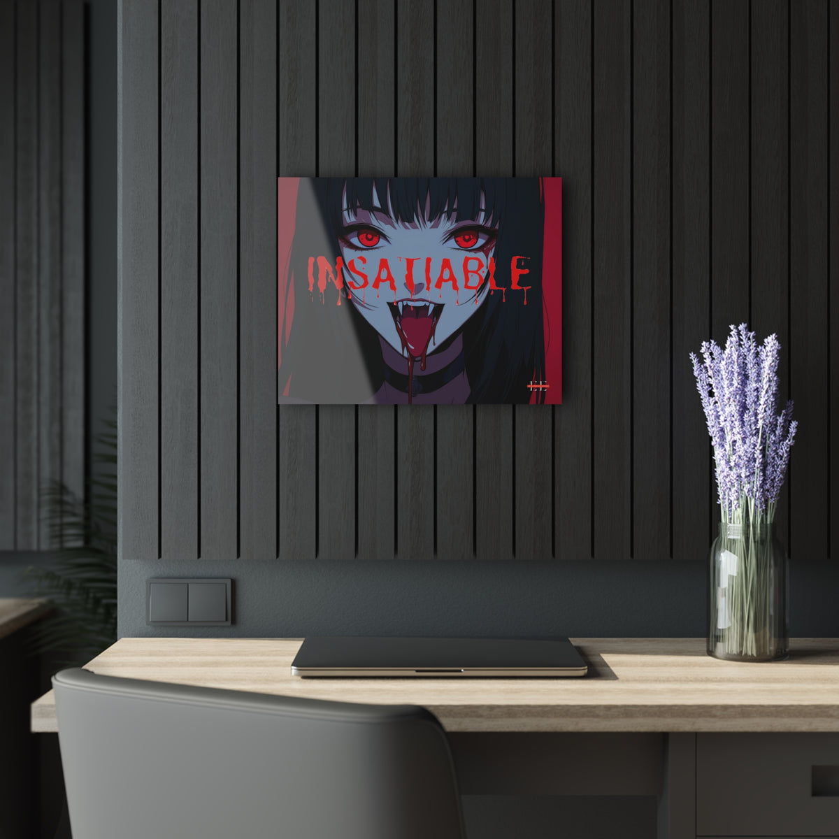 Insatiable acrylic art piece with a dark anime vampire design hanging on a slat wall above a desk.