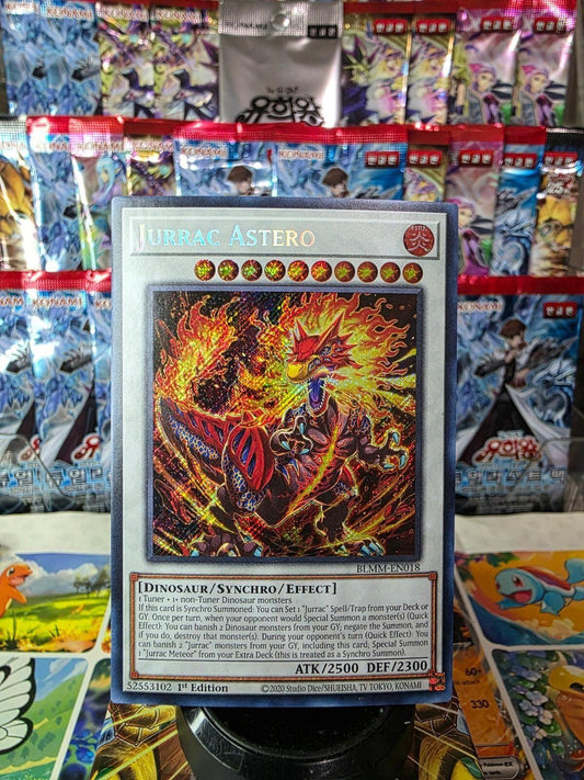 Jurrac Astero Secret Rare Yu-Gi-Oh! card featuring a fiery dinosaur illustration against booster packs.
