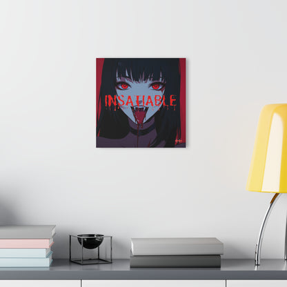"INSATIABLE" acrylic masterpiece hanging on a white wall above books and a yellow lamp.