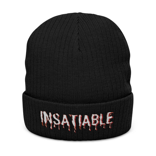 Black cuffed beanie with embroidered white dripping text that reads INSATIABLE.