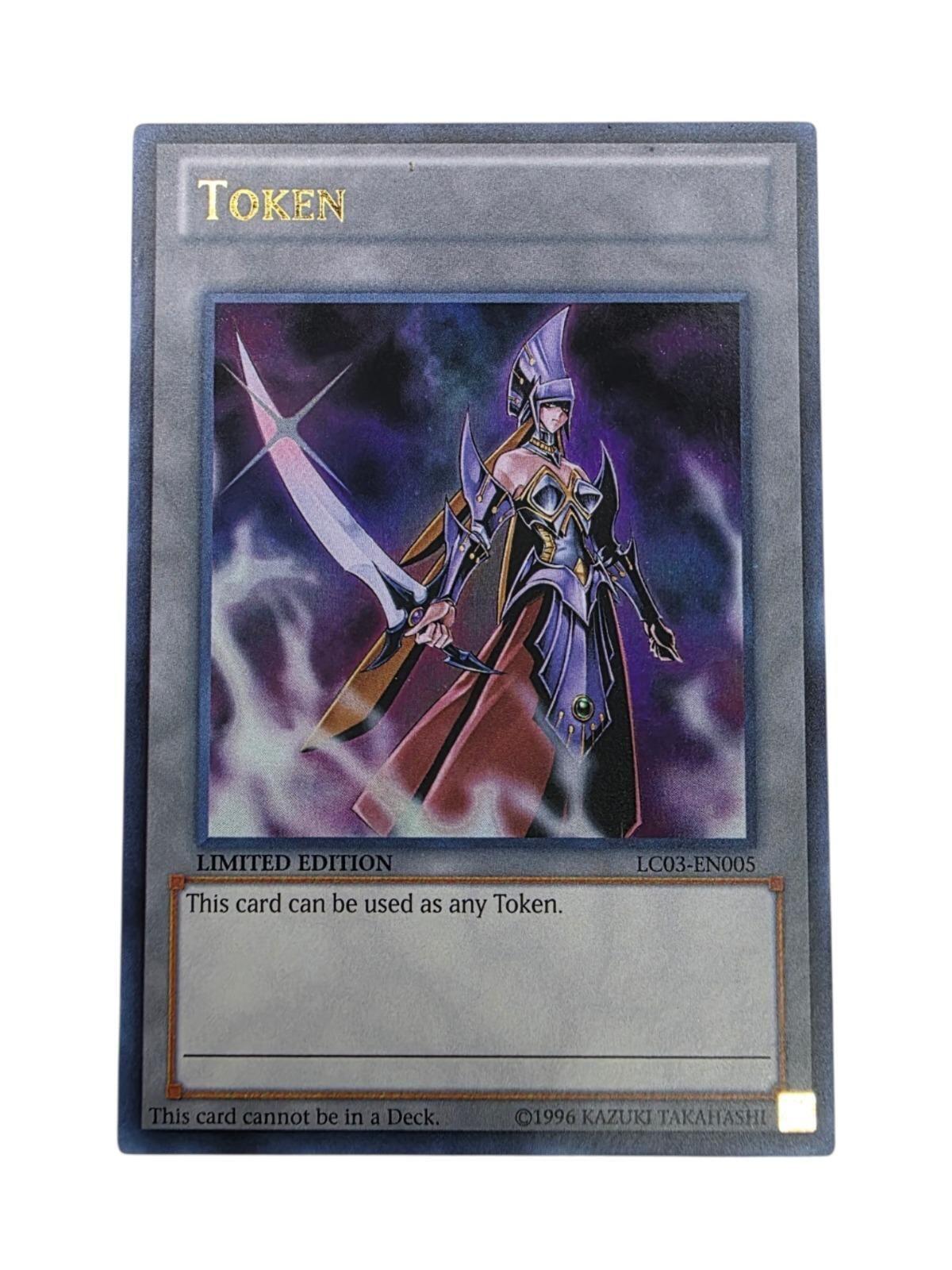 Token: Emissary of Darkness trading card from Yu-Gi-Oh! featuring a warrior in purple armor holding a sword.