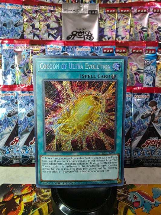 Cocoon of Ultra Evolution Yu-Gi-Oh! card against a colorful booster pack background.