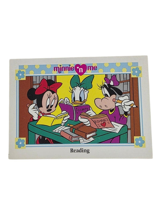 Minnie 'n Me "Reading" trading card featuring Minnie Mouse, Daisy Duck, and Clarabelle Cow reading at a green desk.