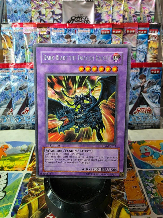 Dark Blade the Dragon Knight Yu-Gi-Oh! card displayed against a background of foil booster packs.