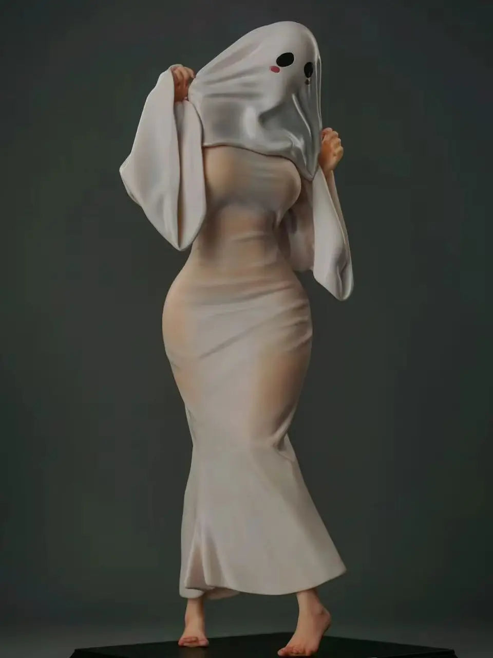 Figurine of a woman wearing a white sheet ghost costume with black eye holes, pink cheeks, and a long white dress.