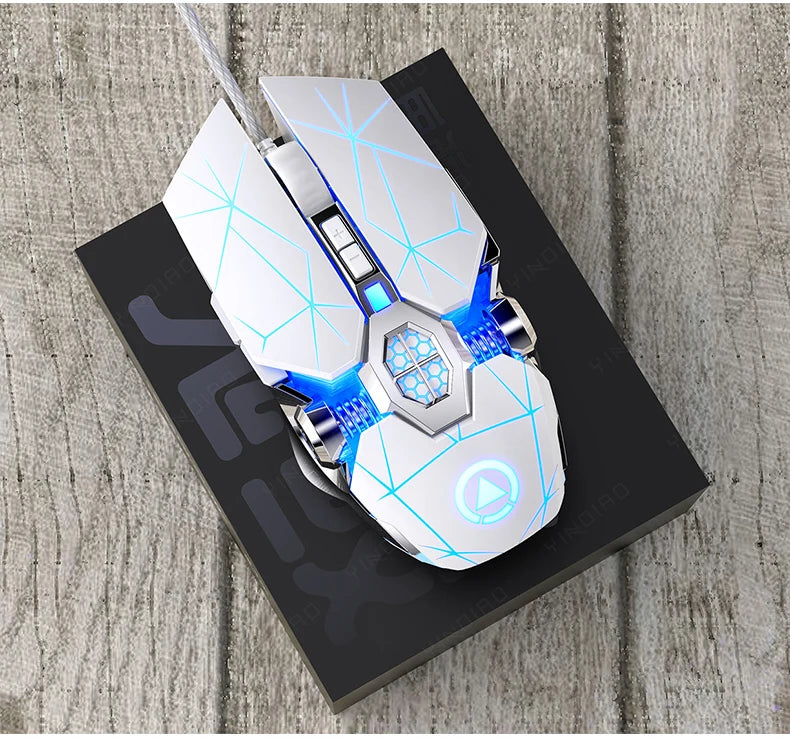 White wired gaming mouse with blue glowing geometric line accents on a black box over a wooden surface.