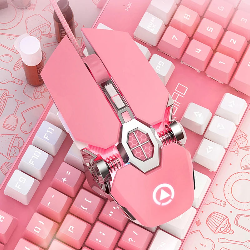 Pink wired gaming mouse with silver mechanical details and a glowing logo, set on a pink keyboard.