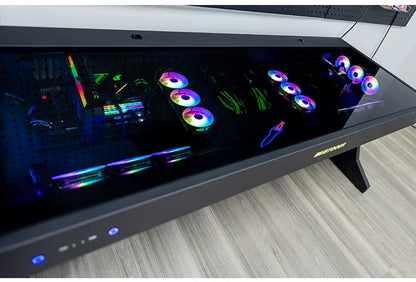 Black desk with a glass top housing two integrated PC builds featuring RGB fans and components.