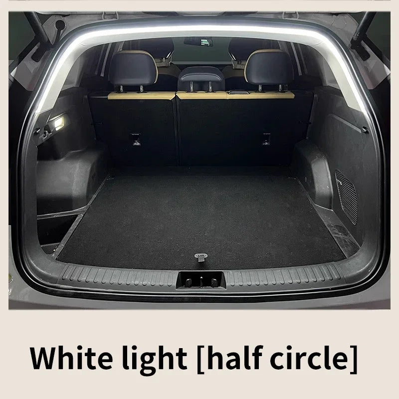 A car trunk with an arched white LED light strip installed along the top edge, illuminating the dark interior.
