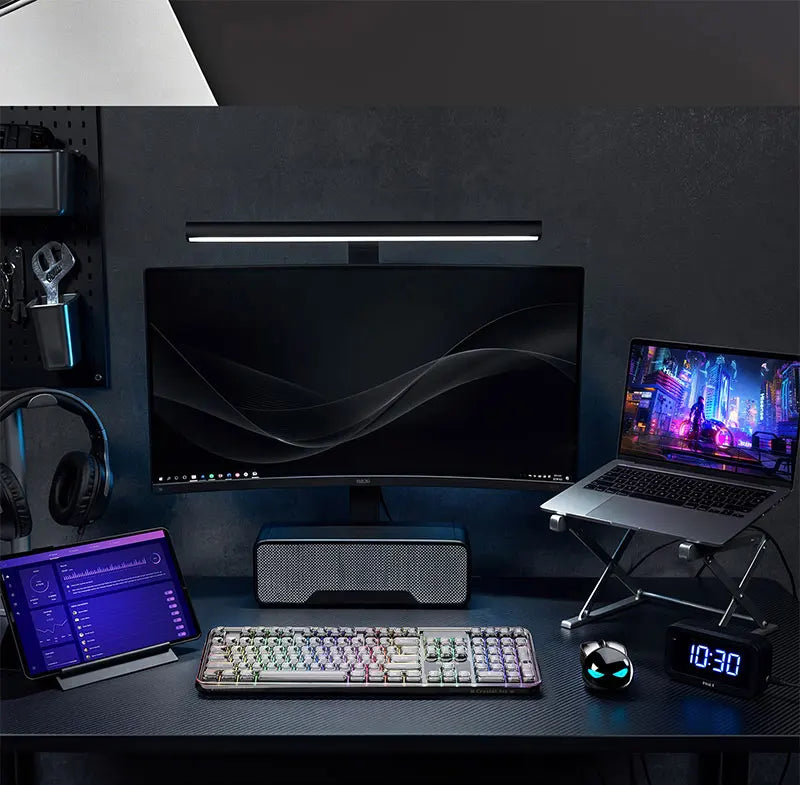Black rabbit-shaped wireless mouse with glowing blue eyes on a desk with a monitor, laptop, and keyboard.