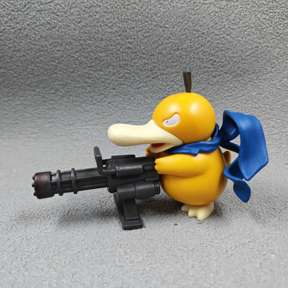 Yellow Psyduck figurine holding a black Gatling gun with a blue scarf flowing behind it.