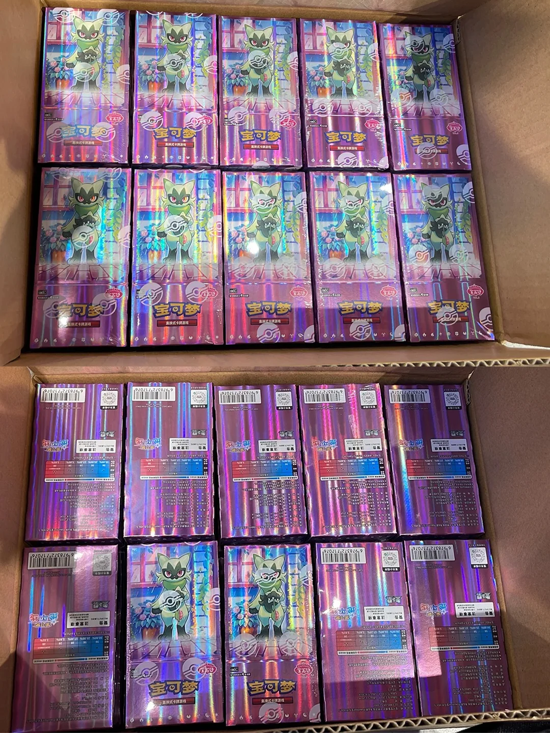 Two open cardboard boxes filled with shiny purple Pokémon Gem Pack 5 booster boxes featuring Sprigatito.