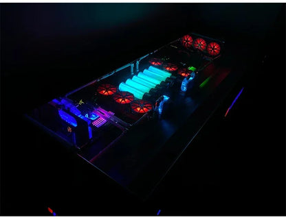 An integrated desk computer chassis glowing with red, blue, and bright green RGB lights in a dark room.