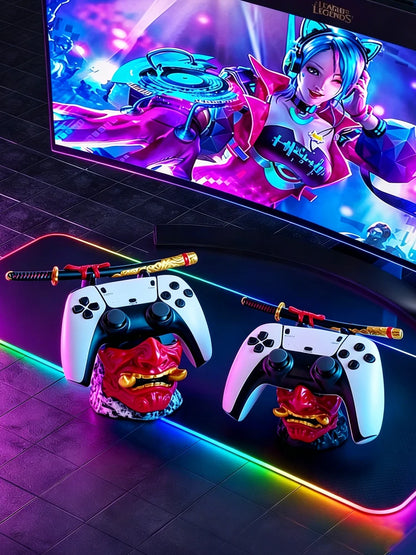 Two red and gold oni mask controller holders, each supporting a white controller and miniature samurai sword.