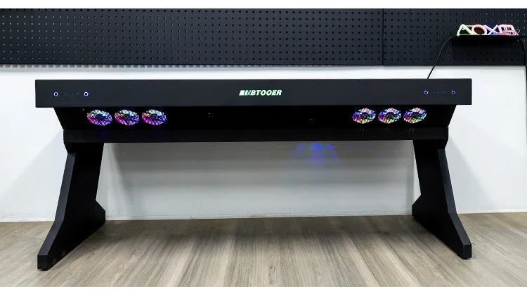 A black desk with an integrated computer chassis, featuring glowing RGB fans and the "BTOOER" logo.