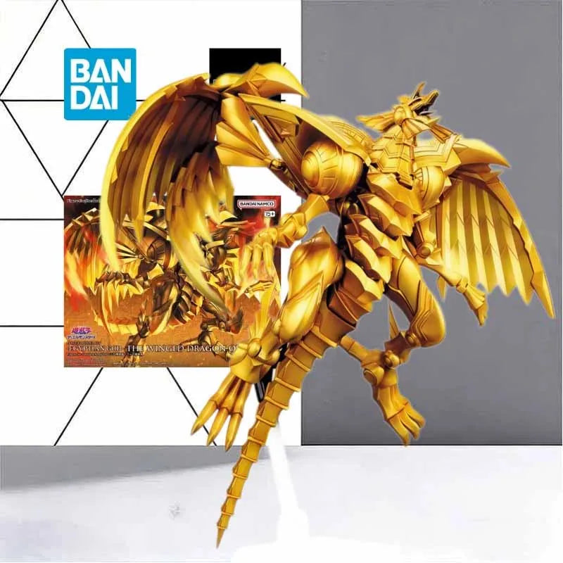 Gold, posable model toy of The Winged Dragon of Ra with large wings, a segmented tail, and packaging box in the background.