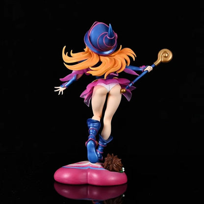 Rear view of a Dark Magician Girl figure holding a staff, wearing a blue hat, pink skirt, and boots on a pink heart base.