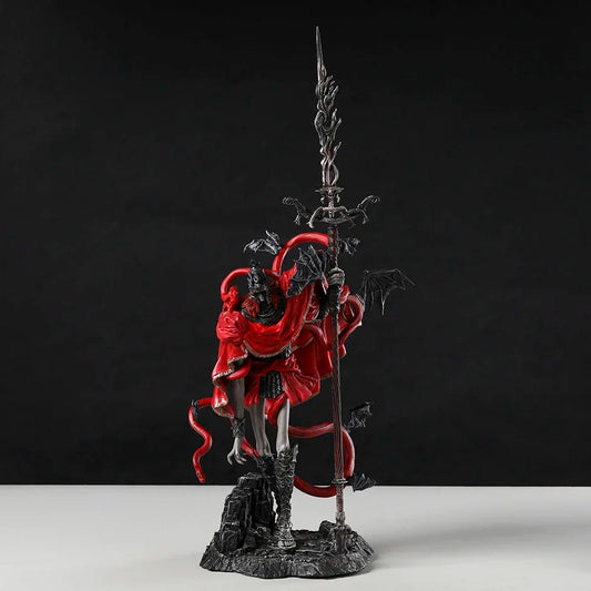 Detailed PVC figurine in red and black, holding a tall ornate spear, with snakes and bat wings, on a rocky base.
