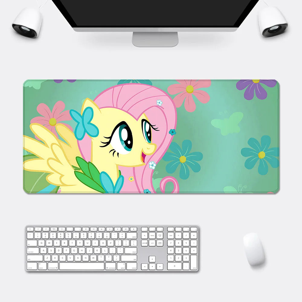 XXL desk mat featuring Fluttershy with pink hair, blue wings, and yellow body against a teal floral background.