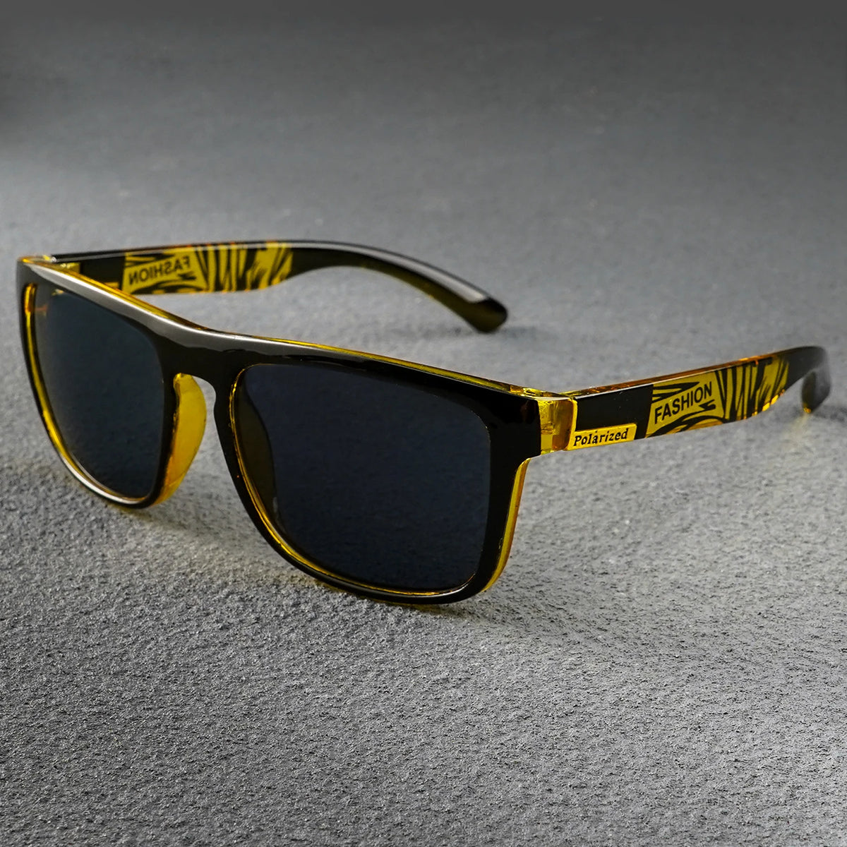 Polarized square sunglasses with black frames, dark lenses, and yellow temples featuring black patterns and "FASHION".
