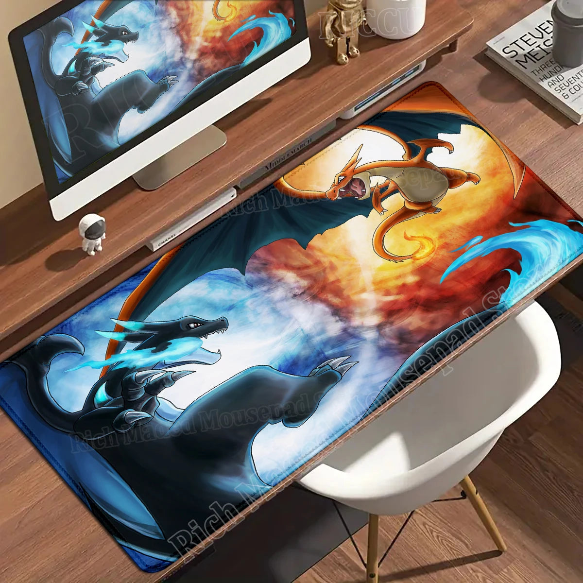 A desk mat featuring orange Charizard and black Mega Charizard X against a fiery, blue-clouded sky.