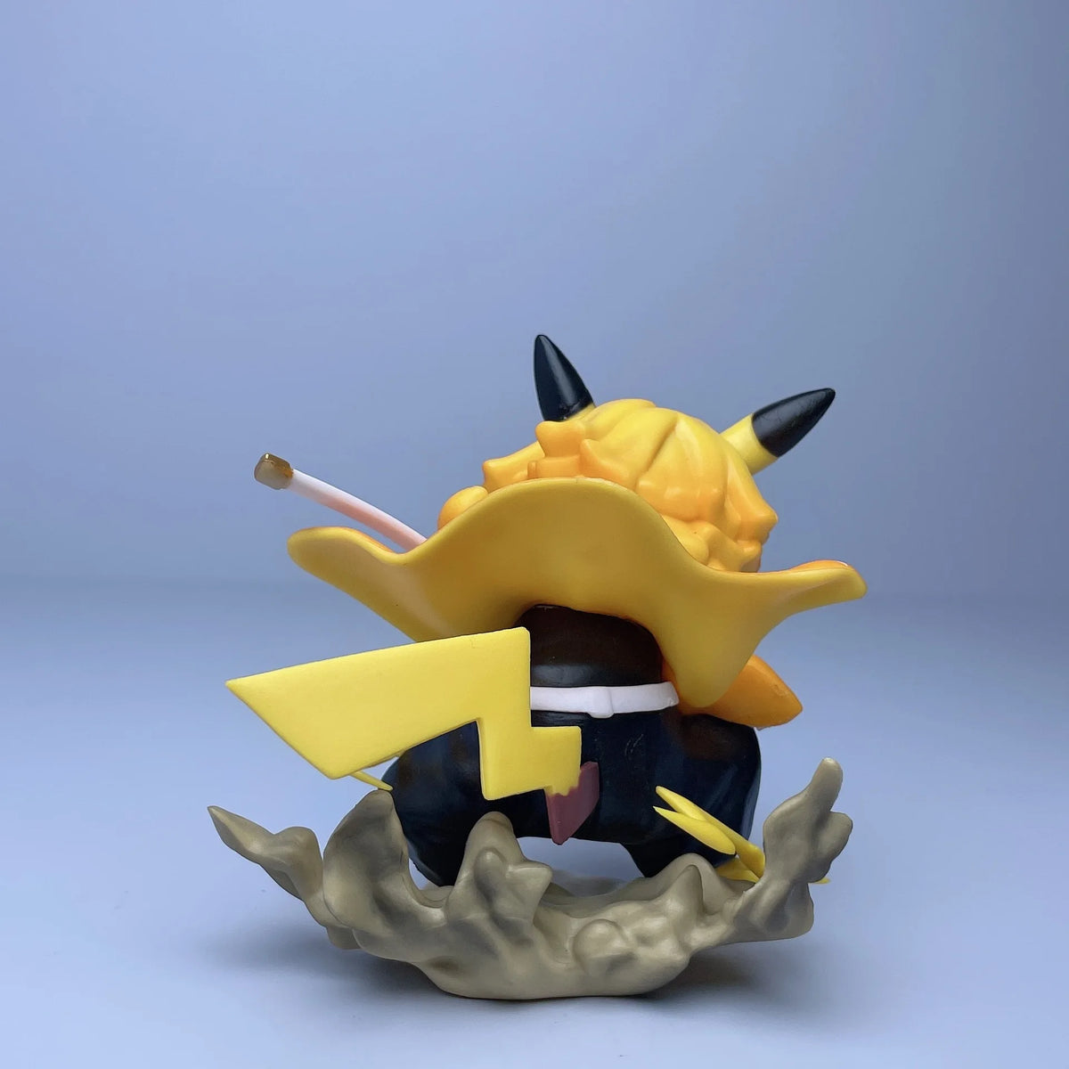 Rear view of a yellow and black Agatsuma Zenitsu figurine with a Pikachu tail and ears on a grey smoke base.