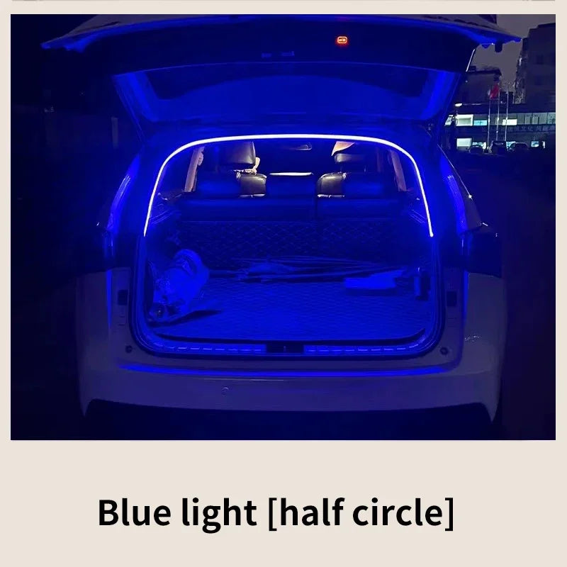 Blue flexible LED light strip illuminates an open car trunk at night.