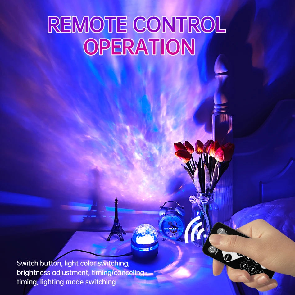 A hand uses a black remote to control a blue and purple galaxy projector on a nightstand with flowers.