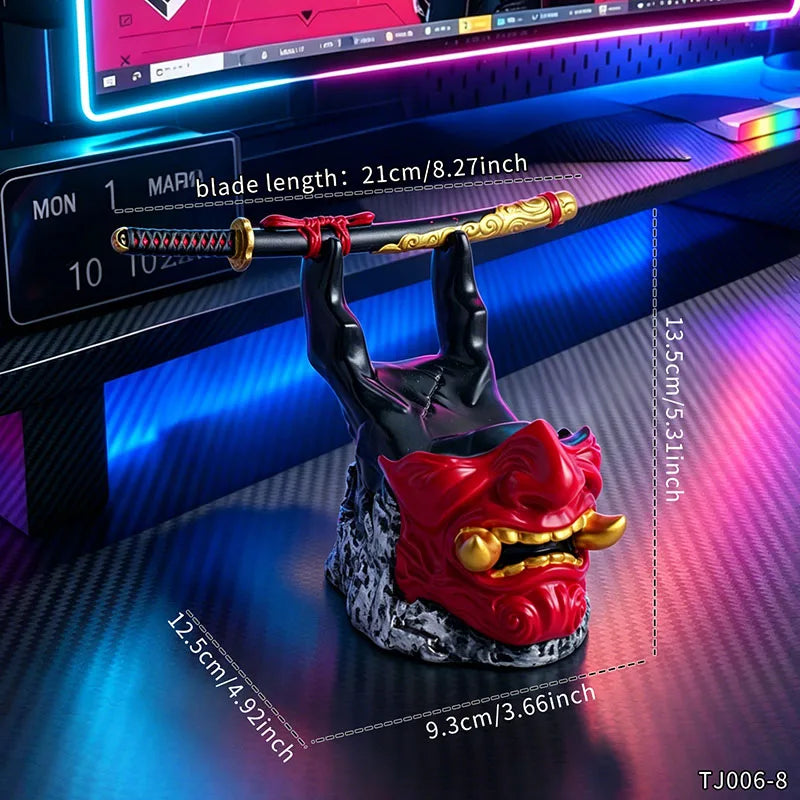 Black and red oni mask game controller holder with a samurai sword, set on a gaming desk.