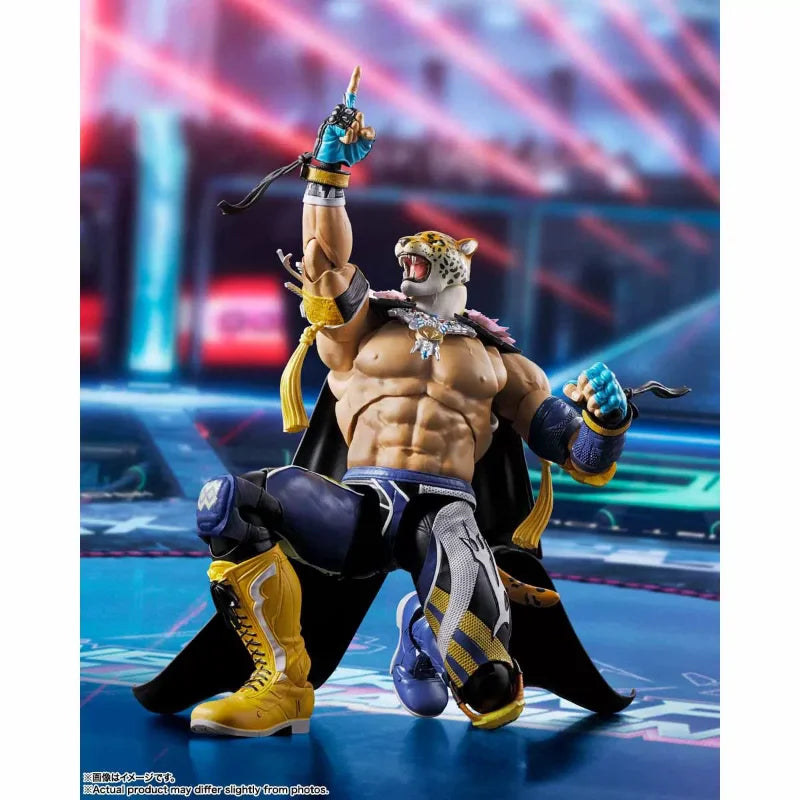 Tekken 8 King action figure kneeling, pointing up, in blue and yellow wrestling gear and a black cape.