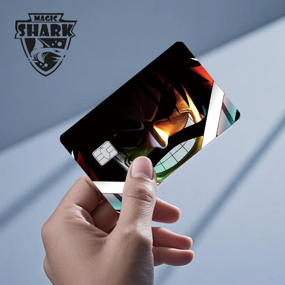 A hand holds a matte black card skin featuring a shadowed anime character face with a wide grin and golden-yellow light.