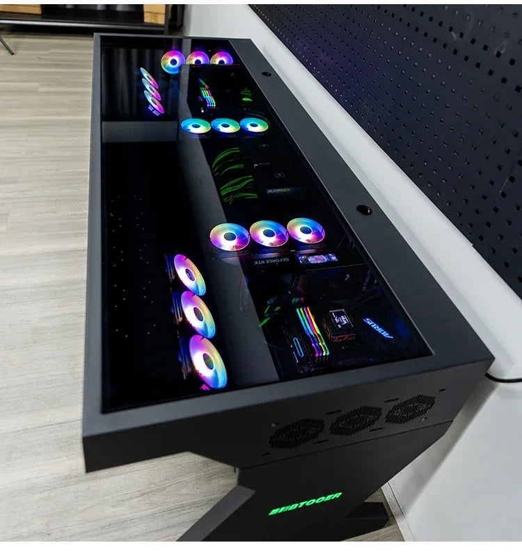 Black computer desk with a glass top housing components, including multiple colorful RGB cooling fans.
