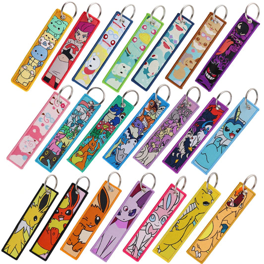 A collection of colorful embroidered anime character jet tag keychains with metal rings.
