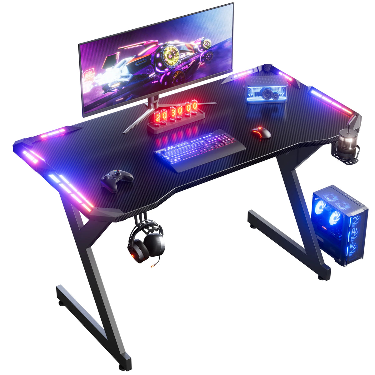 Black Y-shaped gaming desk with carbon-fiber top, RGB lights, monitor, keyboard, mouse, headphones, and PC tower.