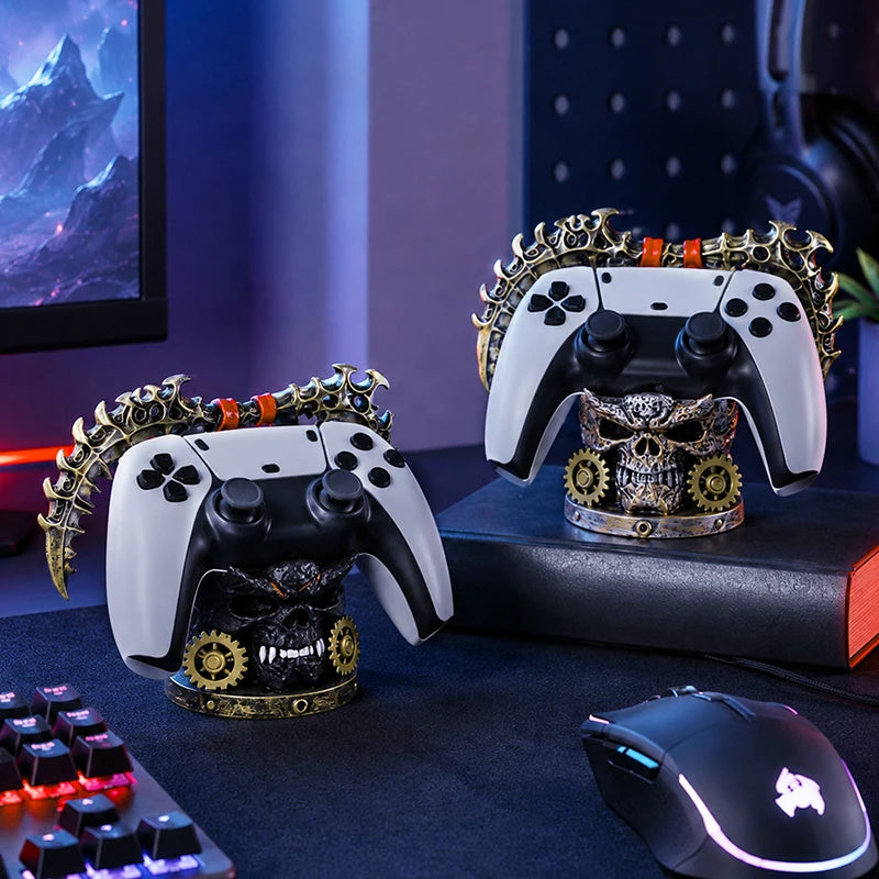 Two steampunk skull controller holders with gold gears, holding white and black gamepads on a desk.