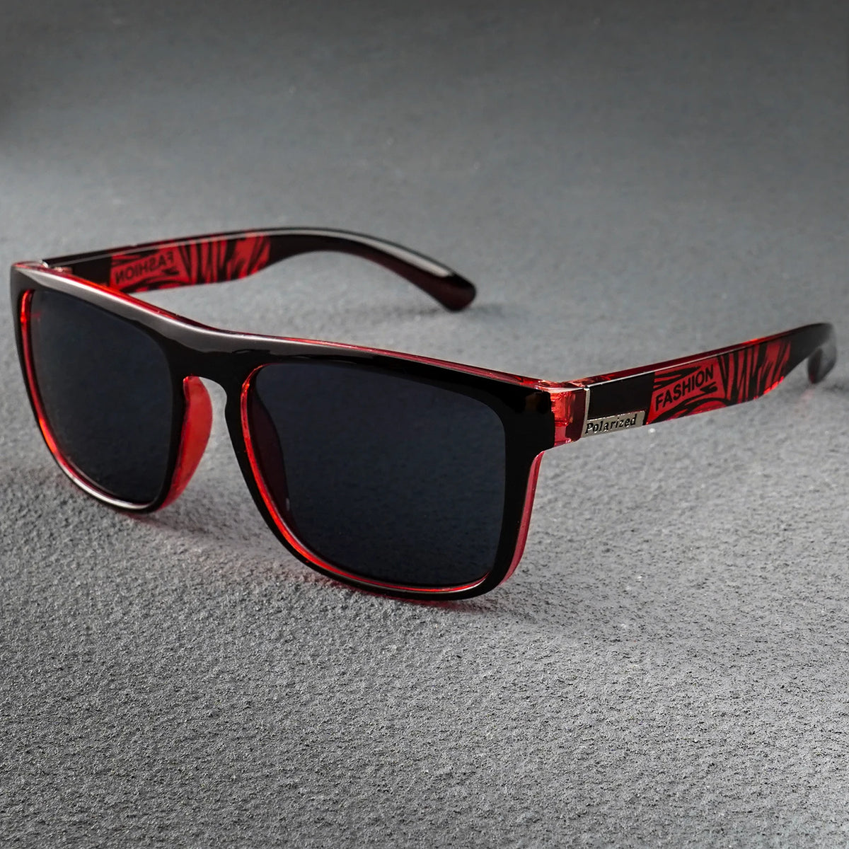 Black square polarized sunglasses with dark lenses, translucent red frames, and "FASHION" text on the temples.