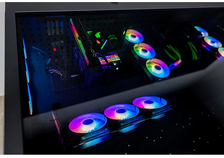 A black computer desk with a glass top reveals internal components and multiple glowing RGB fans.