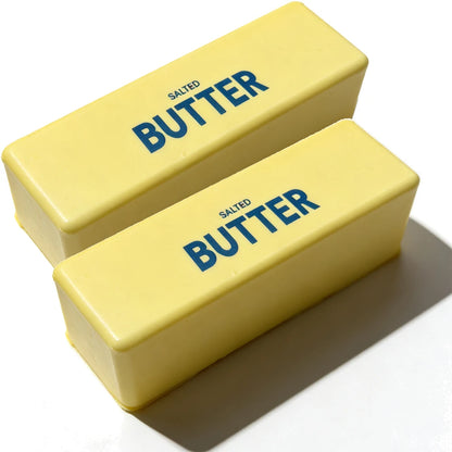 Two yellow stick-of-butter stress toys with blue "SALTED BUTTER" text.