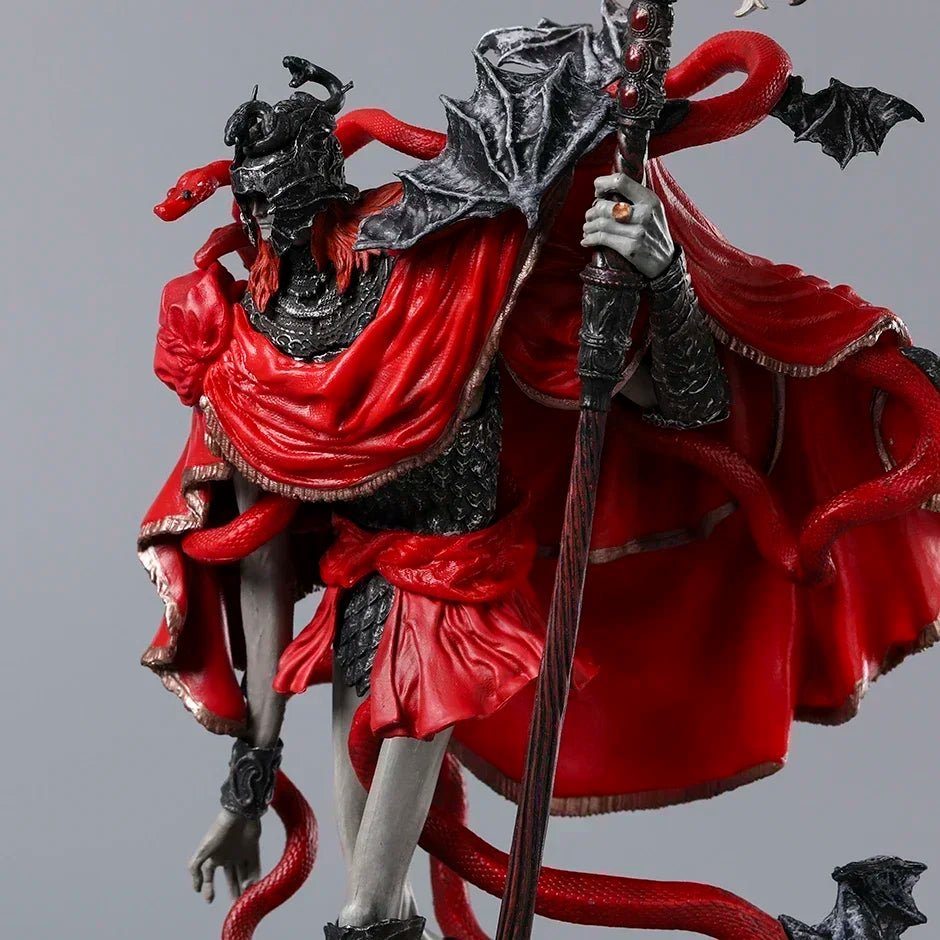 PVC figurine in black and red, wearing a horned helmet, holding a staff, with red snakes wrapped around it.
