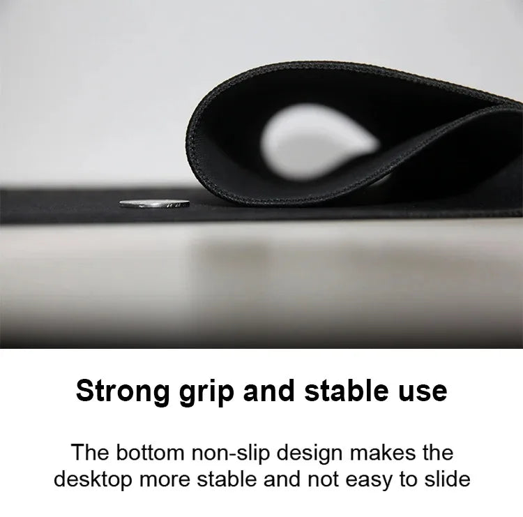 Black mousepad rolled up, showing a stitched locking edge, textured non-slip underside, and a coin on the surface.