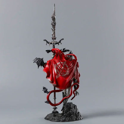 A figurine of a figure holding a tall sword, wearing a red cloak with gold embroidery, and dark wings.