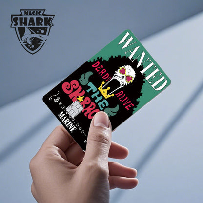 Hand holding a black and green credit card skin with "WANTED" and "DEAD OR ALIVE" text, and a skull icon.