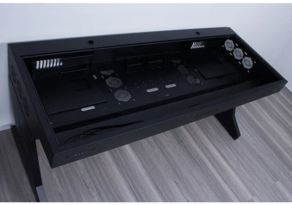 Large black metal computer chassis desk with integrated dual host compartments, vents, and fans on grey wood floor.