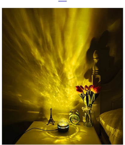 A galaxy projector lamp on a nightstand projects yellow rippling light onto a wall, illuminating a bedside clock, flowers, and decor.
