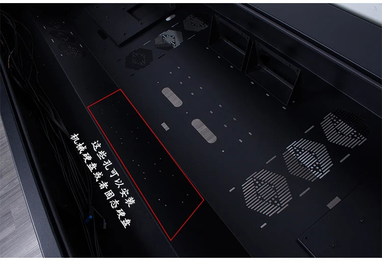Black metal computer chassis interior with fan vents and mounting holes. Red outline highlights a storage area.