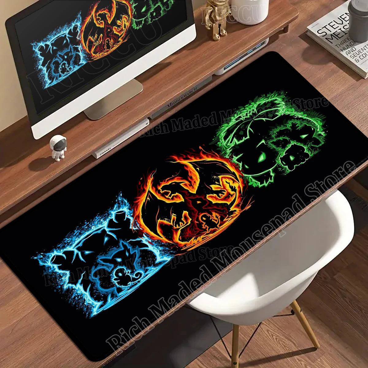 Black desk mat featuring blue, orange, and green elemental character designs on a wooden desk.