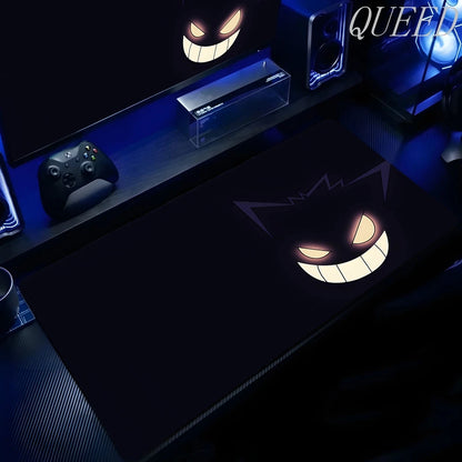Black XXL gaming mouse pad featuring Gengar's glowing yellow eyes and wide smile in a blue-lit setup.