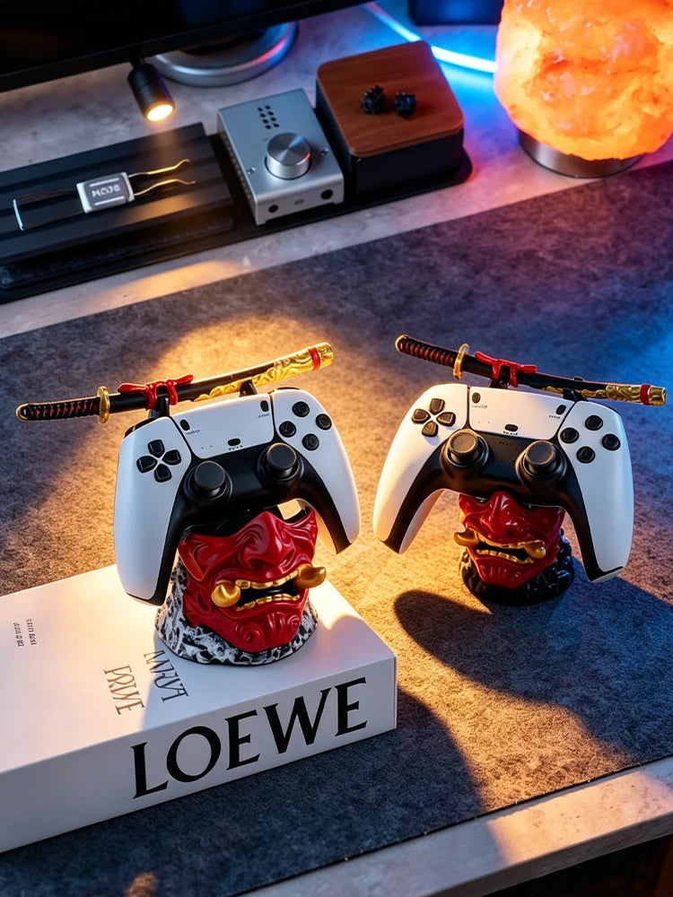 Two red oni mask controller holders with samurai swords, each holding a white and black game controller.