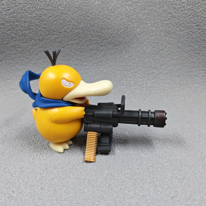 Yellow duck-like figurine with a blue scarf, holding a large black Gatling gun with gold bullets against a grey background.